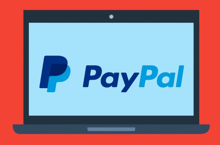 Laptop mit Paypal Logo auf rotem Hintergrund